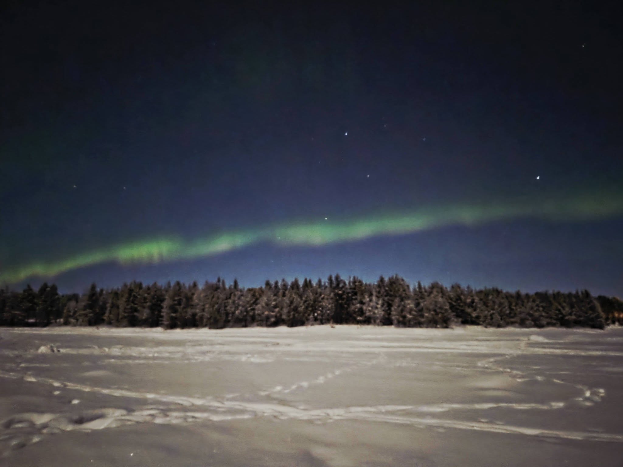 AuroraBorealis green and pink paint brush strokes of light across the dark sky
